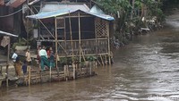 Anak-anak memancing ikan pada bantaran Kali Ciliwung yang menunggu normalisasi di Kawasan Bukit Duri, Jakarta, Jumat (24/1/2025).  