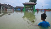 Seorang anak melihat bangunan SD N 1 Setrokalangan yang tergenang banjir di Desa Setrokalangan, Kaliwungu, Kudus, Jawa Tengah, Jumat (24/1/2025).