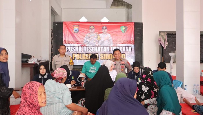 Tim Dokkes Polresta Sidoarjo memberikan pemeriksaan kesehatan gratis warga terdampak banjir