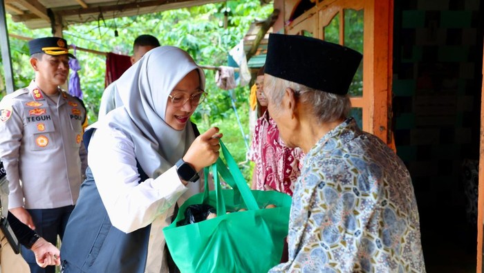 Bupati Ipuk menyerahkan bantuan Gerakan Banyuwangi Berbagi ke warga.