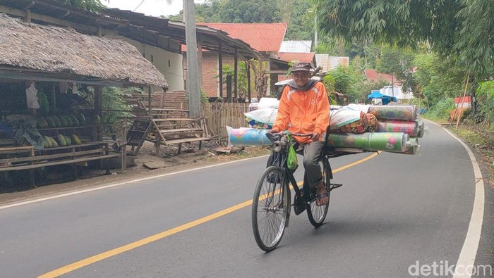 Momen Abd Rauf saat menjual tikar dan bantal menggunakan sepeda di Polman.