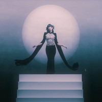 Penggemar semakin penasaran, tak sabar ‘Ruby’ dirilis usai melihat konsep yang disuguhkan. Dalam salah satu adegan, Jennie memakai gaun hitam berbentuk cape rancangan desainer Rusia, YANINA Couture. Bagian tengah gaun berhias payet, memberikan kesan mewah dan elegan. Foto: dok. YouTube JENNIE