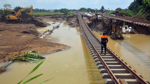 Pekerja melakukan upaya penanganan jalur rel kereta api km 32+5/7 antara Stasiun Gubug-Karangjati yang amblas akibat banjir luapan air Sungai Tuntang di Gubug, Grobogan Jawa Tengah, Minggu (26/1/2025). Rel kereta api dua jalur yang sebelumnya amblas pada Selasa (21/1/2025) akibat banjir dan sudah selesai diperbaiki satu jalur hingga dapat dilalui pada Jumat (24/1) tersebut kembali amblas setelah diterjang banjir susulan pada Sabtu (26/1) dan saat ini PT KAI terus melakukan upaya perbaikan. ANTARA FOTO/Yusuf Nugroho/tom.