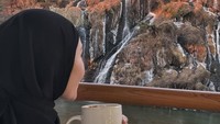 Istri Muhammad Sawkani ini juga sempat menunjukkan pose ketika ngopi di sebuah kafe bertema air terjun yang viral di Seoul. Foto: Instagram @ratnagalih