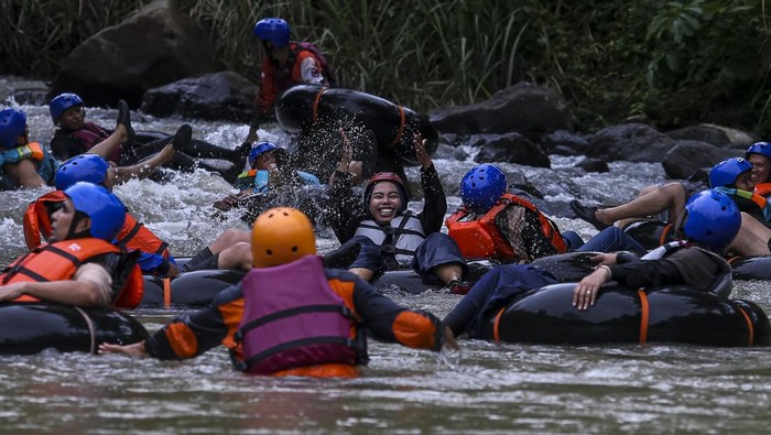 Wisatawan menggunakan ban menyusuri aliran Sungai Cikalumpang saat berwisata alam di Kampoeng 165, Padarincang, Kabupaten Serang, Banten, Sabtu (25/1/2025). Objek wisata alam tersebut menjadi salah satu tujuan wisata yang ramai dikunjungi saat akhir pekan dan liburan dengan menawarkan sejumlah fasilitas seperti area untuk berkemah serta wahana susur sungai menggunakan ban atau river tubing. ANTARA FOTO/Angga Budhiyanto/Spt.