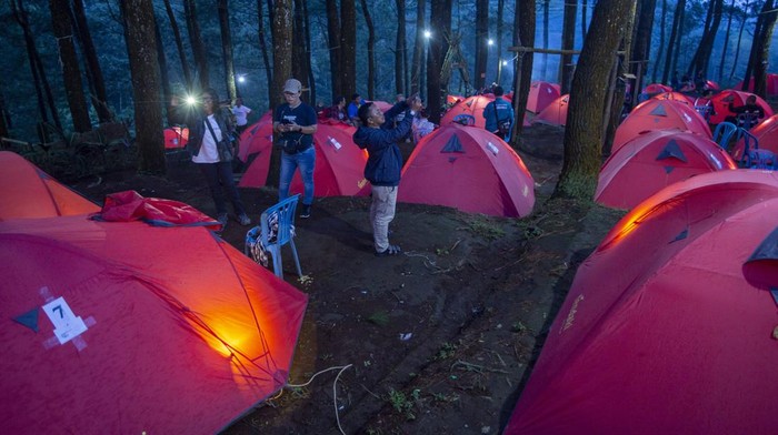 Pengunjung menikmati suasana di camping ground wisata Tenjo laut, Cigugur, Kuningan, Jawa Barat, Minggu (26/1/2025). Destinasi wisata camping ground yang berada di kawasan konservasi Taman Nasional Gunung Ciremai (TNGC) itu menyewakan tenda dengan pemandangan Gunung Ciremai dan Waduk Darma dengan sewa per malam Rp250 ribu hingga Rp1,5 juta. ANTARA FOTO/Dedhez Anggara/foc.