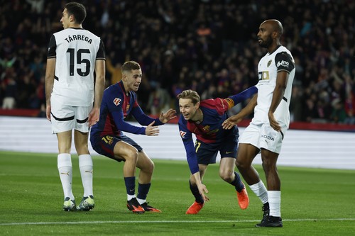 Barcelonas Frenkie de Jong, centre right, celebrates with Fermin Lopez after scoring the opening goal during the Spanish La Liga soccer match between Barcelona and Valencia at the Lluis Companys Olympic Stadium in Barcelona, Spain, Sunday, Jan. 26, 2025. (AP Photo/Joan Monfort)