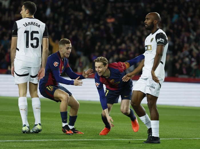 Barcelonas Frenkie de Jong, centre right, celebrates with Fermin Lopez after scoring the opening goal during the Spanish La Liga soccer match between Barcelona and Valencia at the Lluis Companys Olympic Stadium in Barcelona, Spain, Sunday, Jan. 26, 2025. (AP Photo/Joan Monfort)