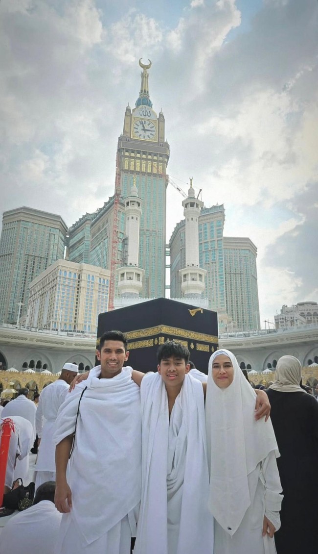 Wanita kelahiran 16 Maret 1982 mengunggah foto bersama anak dan suaminya di depan Ka’bah. Dian Sastro tampil elegan dengan hijab bergo syari, abaya dan sarung tangan serba putih. Foto: Dok. Instagram @therealdisastr.