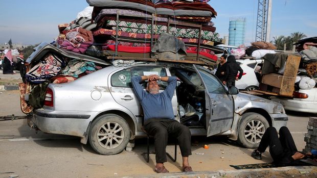 A man sits as Palestinians wait to be allowed to return to their homes in northern Gaza after they were displaced to the south at Israel's order during the war, amid a ceasefire between Israel and Hamas, in the central Gaza Strip, January 26, 2025. REUTERS/Hatem Khaled