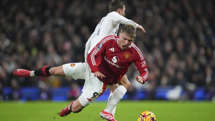 Manchester Uniteds Rasmus Hojlund, front, falls on the pitch challenged by Fulhams Timothy Castagne during the English Premier League soccer match between Fulham and Manchester United at Craven Cottage stadium in London, Sunday, Jan. 26, 2025. (AP Photo/Kirsty Wigglesworth)