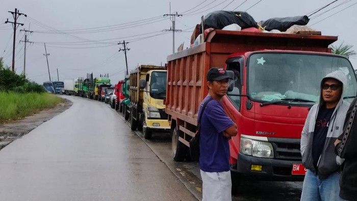Truk angkutan sampah ngantri saat melewati lokasi banjir (Foto: Dok Dinas LH Pelalawan)