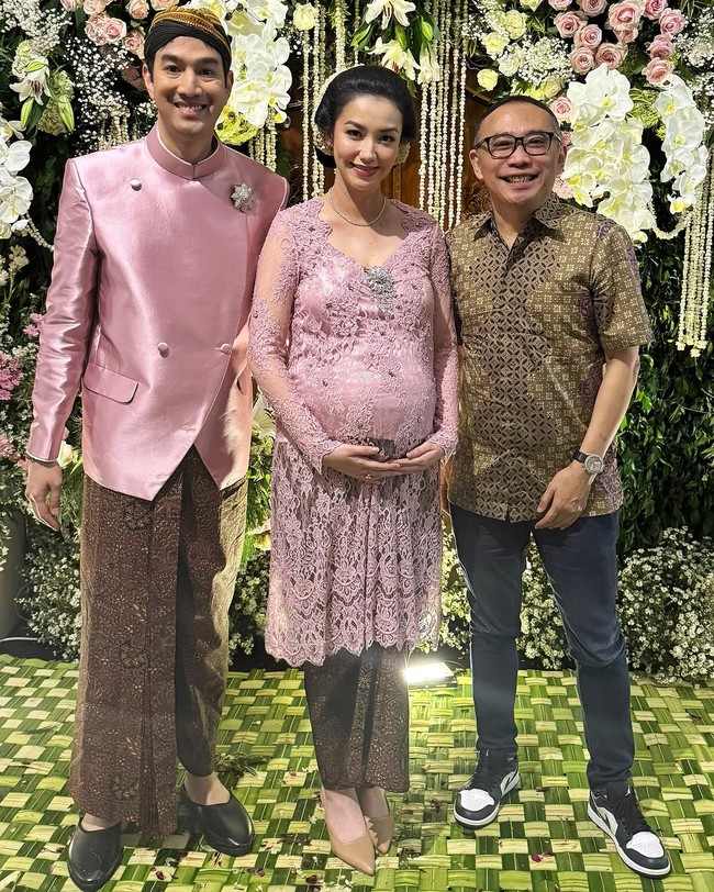 Busananya dilengkapi aksesori bergaya minimalis seperti anting dan kalung berlian. Sang suami, Zakry, memakai beskap warna senada, lengkap dengan blangkon. Foto: Instagram/@jusuf_long @ryanogilvy