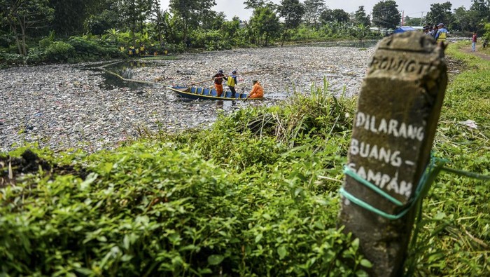 Petugas kebersihan melintas di samping tumpukan sampah yang menumpuk di Sungai Citarum Lama, di Cicukang, Margaasih, Kabupaten Bandung, Jawa Barat, Senin (27/1/2025). Petugas Balai Besar Wilayah Sungai (BBWS) Citarum menyatakan, sampah sepanjang 800 meter dengan lebar sungai 12 meter serta ketinggian mencapai dua meter yang diperkirakan mencapai 19 ton tersebut menumpuk sejak awal Januari 2025 yang saat ini sedang diangkut menggunakan alat berat oleh petugas gabungan. ANTARA FOTO/Raisan Al Farisi/foc.