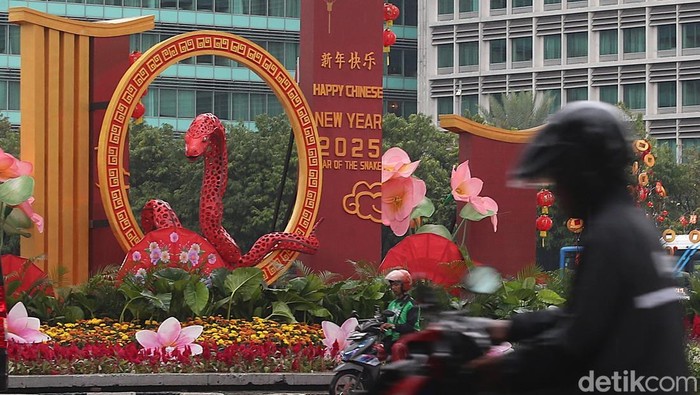 Sejumlah pengendara melintasi dekorasi Tahun Baru Imlek di Bundaran HI, Jakarta, Selasa (28/1/2025).