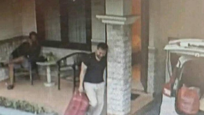 Penampakan Antok, membawa koper merah berisi potongan tubuh Uswatun keluar kamar hotel di Kota Kediri