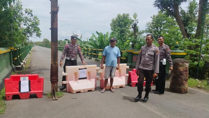 Polisi menutup akses menuju jembatan Srandakan 1, wilayah Galur, Kulon Progo, Selasa (28/1/2025).