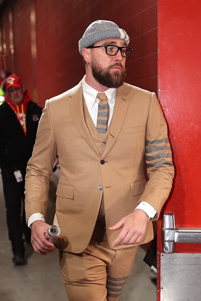 Tak kalah stylish, Travis Kelce mengenakan setelan warna beige dipadu kemeja putih dan dasi dari koleksi Thom Browne. Dia tampak berjalan menuju stadion sebelum pertandingan. Foto: Getty Images/David Eulitt