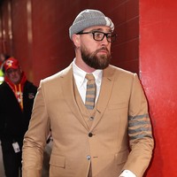 Tak kalah stylish, Travis Kelce mengenakan setelan warna beige dipadu kemeja putih dan dasi dari koleksi Thom Browne. Dia tampak berjalan menuju stadion sebelum pertandingan. Foto: Getty Images/David Eulitt