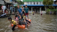 Sejumlah anak asyik bermain banjir di kawasan Rawa Terate, Cakung, Jakarta Timur.