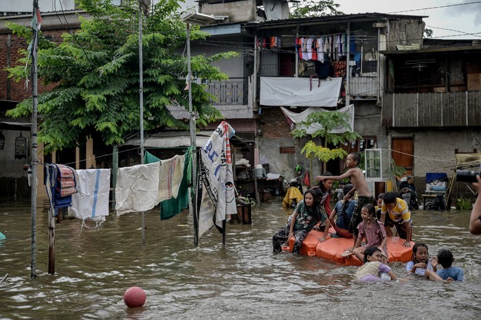 Sejumlah anak bermain di tengah banjir di Rawa Terate, Cakung, Jakarta Timur, Rabu (29/1/2025). BPBD DKI Jakarta mencatat sebanyak 54 RT dan 23 ruas jalan tergenang banjir yang terjadi akibat hujan lebat di wilayah Jakarta sejak Selasa (28/1) malam. ANTARA FOTO/Fauzan/tom.