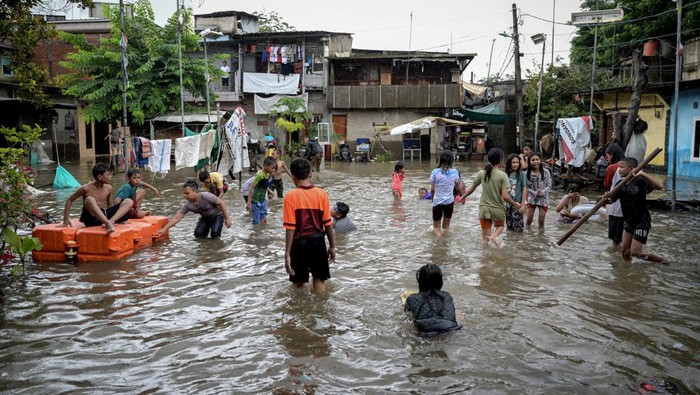 Sejumlah anak bermain di tengah banjir di Rawa Terate, Cakung, Jakarta Timur, Rabu (29/1/2025). BPBD DKI Jakarta mencatat sebanyak 54 RT dan 23 ruas jalan tergenang banjir yang terjadi akibat hujan lebat di wilayah Jakarta sejak Selasa (28/1) malam. ANTARA FOTO/Fauzan/tom.