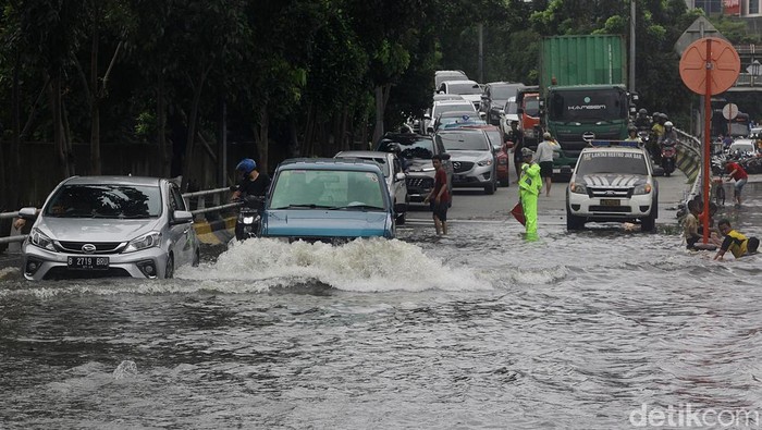 Sejumlah pengendara melewati banjir di Jl Latumenten, Grogol, Jakarta, Rabu  (29/1/2025). Banjir sekitar 50 sentimeter tersebut akibat tingginya intensitas hujan. Akibatnya, arus kendaraan dari arah Slipi menuju Pluit sempat tersendat. Beberapa mobil memilih putar balik di flyover Grogol saat melihat banjir. Air menggenangi jalan hingga menyisakan satu lajur untuk kendaraan. Foto dijepret sekitar pukul 11.30 WIB.