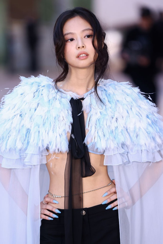 Tanpa dalaman, Jennie hanya memakai bra di balik jubah warna icy blue tersebut, sehingga mengekspos perut dan pinggangnya yang ramping. Foto: WireImage/Marc Piasecki