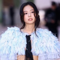 Tanpa dalaman, Jennie hanya memakai bra di balik jubah warna icy blue tersebut, sehingga mengekspos perut dan pinggangnya yang ramping. Foto: WireImage/Marc Piasecki