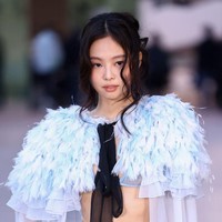 Jennie menata rambutnya dengan sanggul acak dan poni bergelombang yang membingkai lembut wajah mungilnya. Foto: WireImage/Marc Piasecki