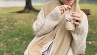 Minum es kopi jadi kegemaren Lesti untuk mengusir dahaga. Saat hamil, ia memilih kopi susu yang lebih ringan sambil bersantai di tepi danau. Foto: Instagram/lestikejora