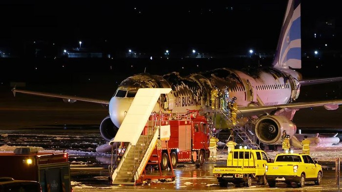 Firefighters work on an Air Busan plane that caught fire at Gimhae International Airport in Busan, South Korea, January 29, 2025. Yonhap/via REUTERS Purchase Licensing Rights