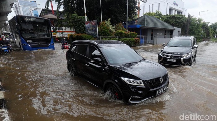 Pengendara nekat menerobos banjir di  Jalan Boulevard Barat Raya, Kelapa Gading, Jakarta Utara, Rabu (29/1/2025).
