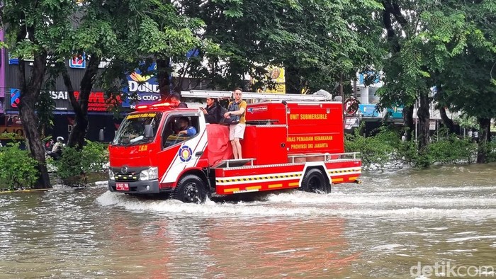 Situasi ruas jalan di Kelapa Gading terendam banjir hingga Rabu (29/1/2025) siang. Tampak warga mengevakuasi motor dengan perahu yang dimodifikasi. Mobil damkar pun dikerahkan mengevakuasi warga. Foto: Taufiq/detikcom