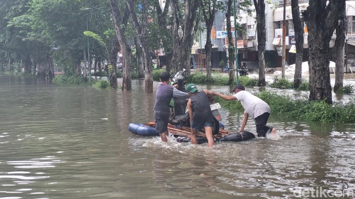 Situasi ruas jalan di Kelapa Gading terendam banjir hingga Rabu (29/1/2025) siang. Tampak warga mengevakuasi motor dengan perahu yang dimodifikasi. Mobil damkar pun dikerahkan mengevakuasi warga. Foto: Taufiq/detikcom