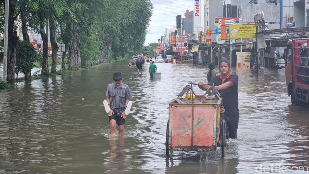 Situasi ruas jalan di Kelapa Gading terendam banjir hingga Rabu (29/1/2025) siang. Tampak warga mengevakuasi motor dengan perahu yang dimodifikasi. Mobil damkar pun dikerahkan mengevakuasi warga. Foto: Taufiq/detikcom