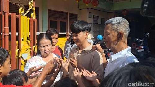 Suasana pembagian angpao yang dilakukan salah satu jemaat kepada anak-anak di sekitar Kelenteng Po Hwa Kong, Ampenan, Kota Mataram, NTB, Rabu (29/1/2025). (Foto: Nathea Citra/detikBali)