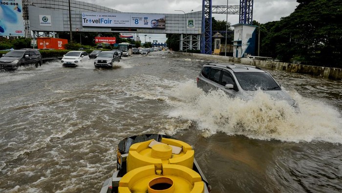 Polisi mengatur lalu lintas kendaraan saat banjir di Jalan Tol Sedyatmo, Cengkareng, Jakarta, Rabu (29/1/2025). Jalan tol yang merupakan akses menuju Bandara Soekarno-Hatta tersebut terendam banjir setinggi 20-30 sentimeter akibat tingginya intensitas hujan. ANTARA FOTO/Putra M. Akbar/gp/tom.