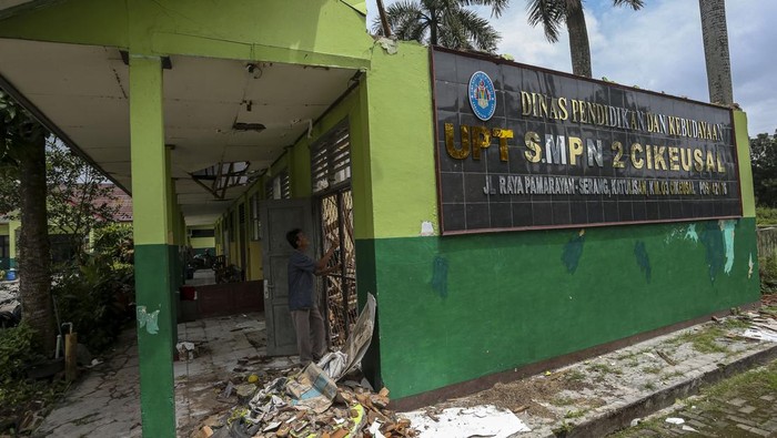 Bangunan sekolah rusak di Kabupaten Serang Tiga siswi berjalan di dekat ruang kelas yang rusak di SMP Negeri 2 Cikeusal, Kabupaten Serang, Banten, Kamis (30/1/2025). Pihak sekolah mengatakan, sebanyak tiga ruang kelas mengalami kerusakan parah sejak Februari 2024 sementara satu ruang kelas lainnya ambruk pada 18 Januari 2025 akibat kondisi bangunan tua dan faktor cuaca sehingga kegiatan belajar mengajar harus dipindahkan ke ruangan lain yang kondisi bangunannya masih layak. ANTARA FOTO/Angga Budhiyanto/nym.
