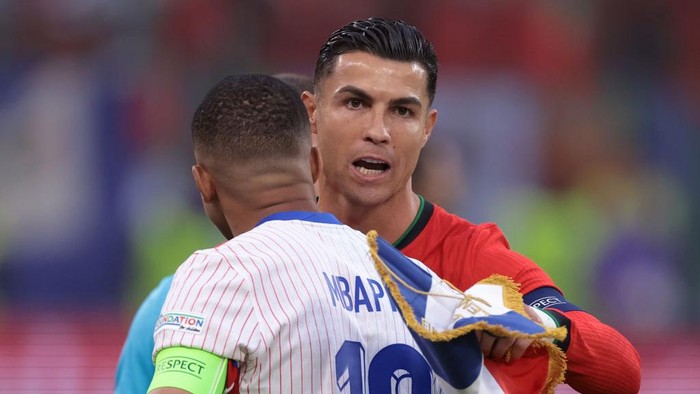 HAMBURG, GERMANY - JULY 05: Cristiano Ronaldo of Portugal and Kylian Mbappe of France embrace after exchanging pennants prior to kick off in the UEFA EURO 2024 quarter-final match between Portugal and France at Volksparkstadion on July 05, 2024 in Hamburg, Germany. (Photo by Jonathan Moscrop/Getty Images)