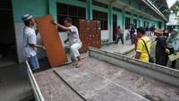Pekerja mengangkut lemari untuk dipindahkan saat eksekusi bangunan sekolah Yayasan Pendidikan Trisila di Jalan Undaan Kulon, Surabaya, Jawa Timur, Kamis (30/1/2025).  