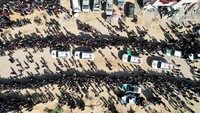 Pemandangan drone menunjukkan orang-orang berkumpul di dekat kendaraan Komite Palang Merah Internasional (ICRC), saat menyerahkan sandera di Khan Younis di Jalur Gaza selatan, 30 Januari 2025. 
