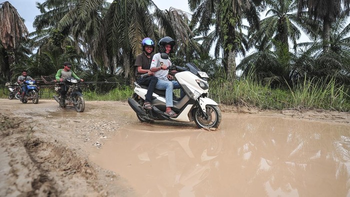 Pengendara sepeda motor menerobos jalan yang terendam banjir di Desa Tanjung Lebar, Muaro Jambi, Jambi, Kamis (30/1/2025). Jalan penghubung satu-satunya sejumlah desa di Kecamatan Bahar Selatan dengan Sungai Bahar itu terendam banjir akibat meluapnya Sungai Tanjung Lebar hingga ketinggian 40 sentimeter setelah diguyur hujan dengan intensitas sedang hingga lebat sejak lima hari terakhir. ANTARA FOTO/Wahdi Septiawan/tom.