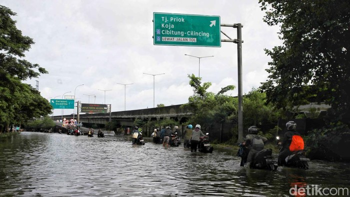 Jalan Raya Cakung Cilincing Lumpuh Imbas Banjir Sejumlah warga menerobos banjir di kawasan Jalan Raya Cakung Cilincing, Jakarta Utara, Kamis (30/1/2024).