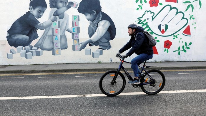 A man walks past a mural by Emmalene Blake asking for peace, in solidarity with Palestinians in Gaza, in Dublin, Ireland, January 30, 2025. REUTERS/Clodagh Kilcoyne