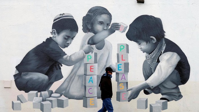 Mural Dukung Palestina di Dublin A man walks past a mural by Emmalene Blake asking for peace, in solidarity with Palestinians in Gaza, in Dublin, Ireland, January 30, 2025. REUTERS/Clodagh Kilcoyne