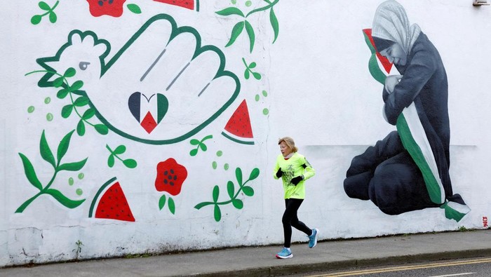 Mural Dukung Palestina di Dublin A man walks past a mural by Emmalene Blake asking for peace, in solidarity with Palestinians in Gaza, in Dublin, Ireland, January 30, 2025. REUTERS/Clodagh Kilcoyne