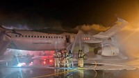 Petugas pemadam kebakaran berusaha memadamkan api dari pesawat Air Busan di Bandara Internasional Gimhae di Busan, Korea Selatan, Rabu (28/1/2025). (REUTERS/Yonhap News Agency)  