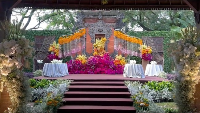 Taman gapura di halaman depan rumah juga tampak dipercantik dengan bunga-bunga berwarna cerah, membuat dekorasi terlihat lebih hidup. Agar semakin kental adat Jawa, suara gamelan juga turut mengiringi pernikahan. Foto: Instagram/@bimo_singgih
