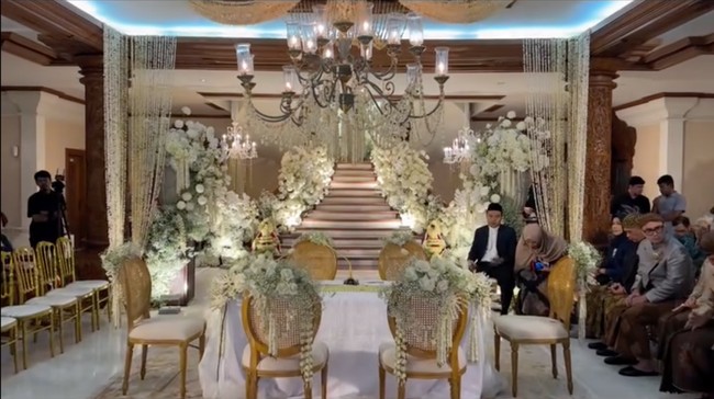 Acara pernikahan digelar di rumah kakek buyut mempelai pria. Hari bahagia pernikahan keduanya dipenuhi pesona klasik Jawa-Bali dengan nuansa kerajaan, warisan, dan kemewahan etnik. Bunga-bunga berwarna putih menambah keindahan dekorasi pernikahan. Foto: Instagram/@bimo_singgih